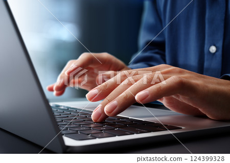 Close-up of hands typing on laptop keyboard. Businessman working at desk in office. 124399328