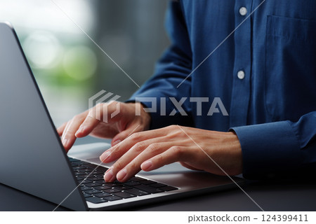 在筆記型電腦鍵盤上打字的手的特寫。商務人士在辦公室的辦公桌上工作。工作技巧 124399411