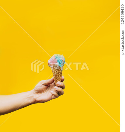 Hand holding ice cream cone on yellow background. Hand holding a waffle cone ice cream isolated. Waffle cone ice cream concept on yellow background Hand holding ice cream cone on yellow background. Hand holding a waffle cone ice cream isolated. Waffle cone ice cream concept on yellow background 124399430