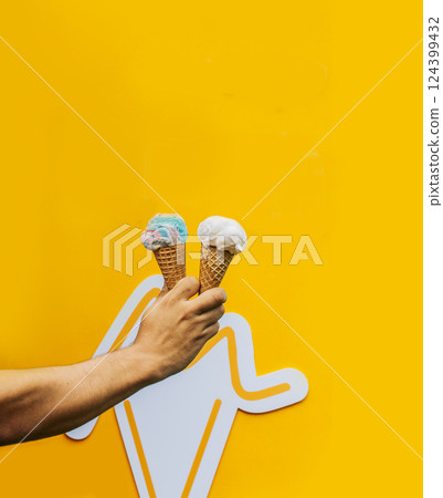 Hand holding two waffle cone ice cream isolated. Hand holding two ice cream cone on yellow background. Waffle cone ice cream concept on yellow background Hand holding two waffle cone ice cream isolated. Hand holding two ice cream cone on yellow background. Waffle cone ice cream concept on yellow background 124399432