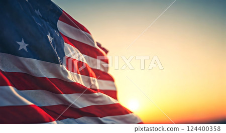 American flag waving in the breeze with sunset out of focus. 124400358