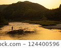 A man fishing in a river at dusk 124400596