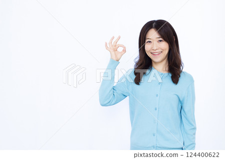 A woman smiling and making an OK sign A woman smiling and making an OK sign 124400622