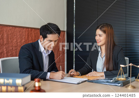Client Consultation and Document Preparation. A lawyer collaborating with a client on important legal matters in her office. Client Consultation and Document Preparation. A lawyer collaborating with a client on important legal matters in her office. 124401485