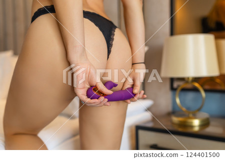 A slender woman holds a dildo in her hand. Toys for adults. A slender woman holds a dildo in her hand. Toys for adults. 124401500