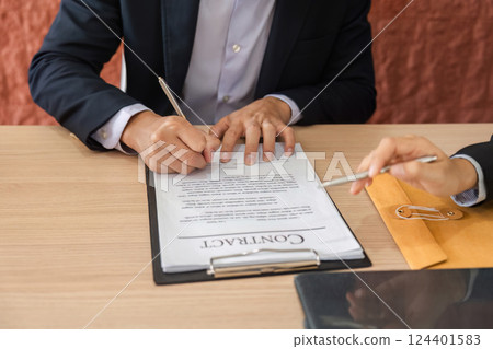 Business Agreements and Legal Proceedings. Individuals signing a contract in a professional setting. Business Agreements and Legal Proceedings. Individuals signing a contract in a professional setting. 124401583