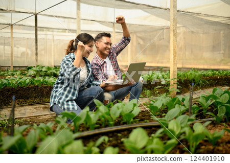 Happy farmers celebrating success after reviewing positive farming results on laptop Happy farmers celebrating success after reviewing positive farming results on laptop 124401910