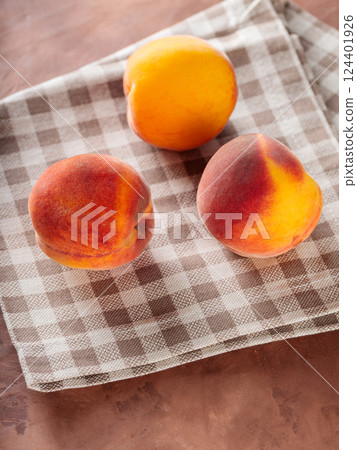 Ripe Peaches on Beige Linen Napkin 124401926