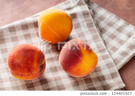 Ripe Peaches on Beige Linen Napkin 124401927