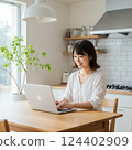 一位身穿白襯衫的女士在筆記型電腦上工作 124402909