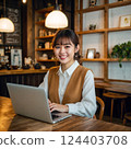 在咖啡館裡用筆記型電腦工作的微笑女人 124403708