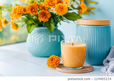 A candle sitting on top of a table next to a vase of flowers 124405214