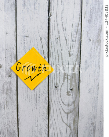 Vibrant sticky note with the word Growth positioned against a textured wooden background, representing the themes of personal development and advancing toward goals Vibrant sticky note with the word Growth positioned against a textured wooden background, representing the themes of personal development and advancing toward goals 124405832
