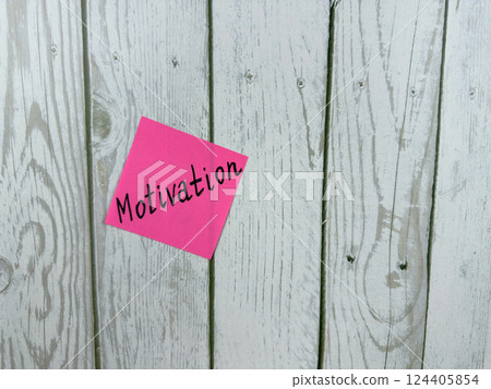 Pink sticky note with the word Motivation written on it, pinned on a white wooden board background. The image symbolizes inspiration, drive, and determination. Excellent for concept themes Pink sticky note with the word Motivation written on it, pinned on a white wooden board background. The image symbolizes inspiration, drive, and determination. Excellent for concept themes 124405854