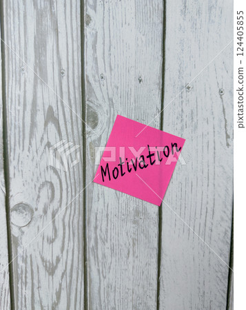 Pink sticky note with the word Motivation written on it, placed on a white wooden background. Ideal for themes of inspiration, determination, and achieving goals. Perfect for motivation concept Pink sticky note with the word Motivation written on it, placed on a white wooden background. Ideal for themes of inspiration, determination, and achieving goals. Perfect for motivation concept 124405855