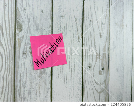 Sticky note with Motivation written on it, affixed to a white wooden board. Representing inspiration and drive, this image is perfect for concepts of personal growth and determination Sticky note with Motivation written on it, affixed to a white wooden board. Representing inspiration and drive, this image is perfect for concepts of personal growth and determination 124405856