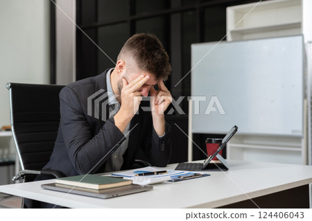 Young stressed caucasian businessman working in the office. Young stressed caucasian businessman working in the office. 124406043
