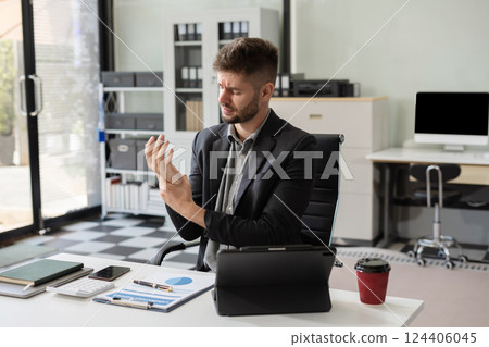 Male businessman is doing a stretchy posture due to sitting in the office for too long, office syndrome concept. 124406045