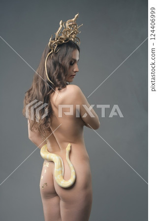 Woman poses elegantly with a snake, showcasing beauty and artistry 124406999
