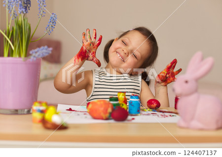 happy funny child girl is showing hands dirty with paint at home 124407137