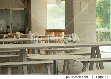Serene cafe interior features minimalist tables and soft lighting. 124408313