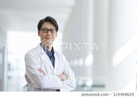 一名 40 多歲的男子身穿白大褂,雙手交叉,看著鏡頭 一名 40 多歲的男子身穿白大褂,雙手交叉,看著鏡頭 124408629