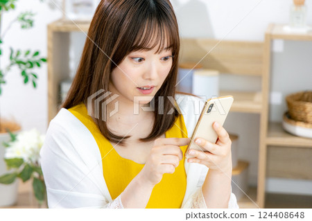 Young woman looking at a smartphone Young woman looking at a smartphone 124408648