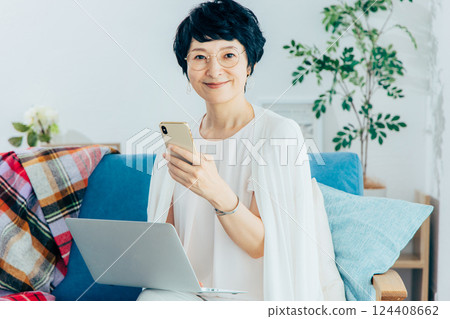 在客廳裡使用電腦的中年女人 124408662