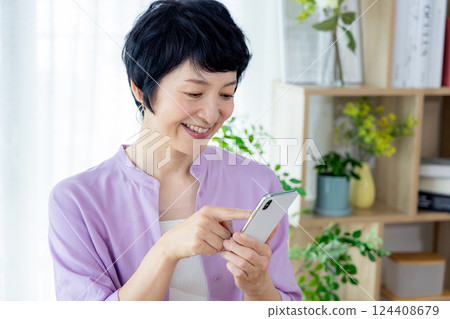 Middle-aged woman operating a smartphone 124408679