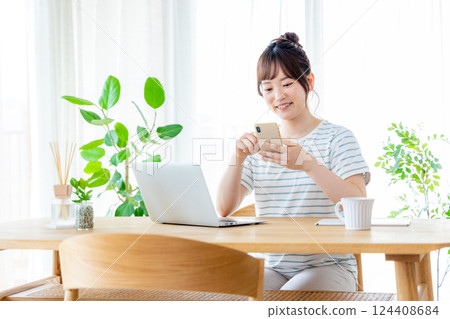 在客廳裡使用智能手機的年輕女子 124408684