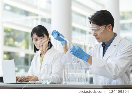 身穿白大褂的中年男子和女子進行實驗 身穿白大褂的中年男子和女子進行實驗 124409294