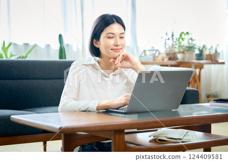 年輕女子在房間裡操作電腦 124409581