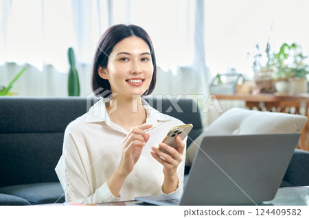 年輕女子在房間裡操作電腦 124409582