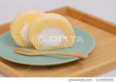 Cream-filled roll cake served on a wooden tray Cream-filled roll cake served on a wooden tray 124409589