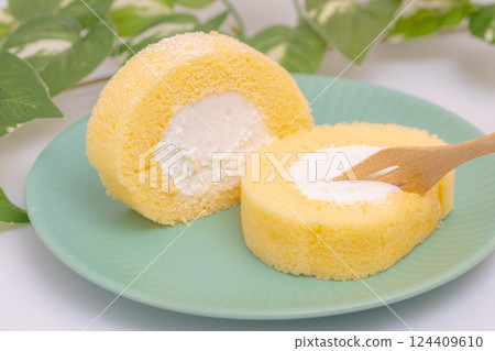 A cream-filled roll cake cut and eaten with a fork 124409610