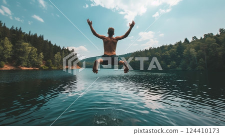 A captivating image shows a person mid-jump into a serene lake, embodying joyful, spontaneous fun. 124410173