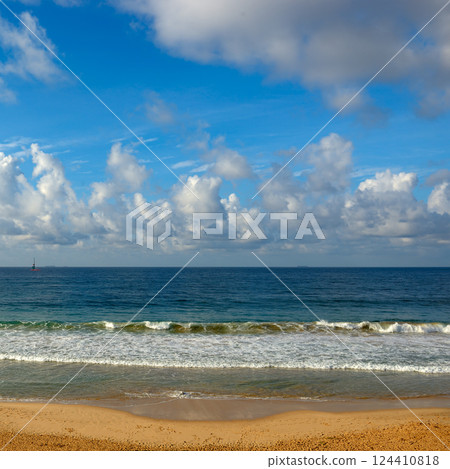 Clear sunny day at seaside. Yellow sand and blue ocean 124410818