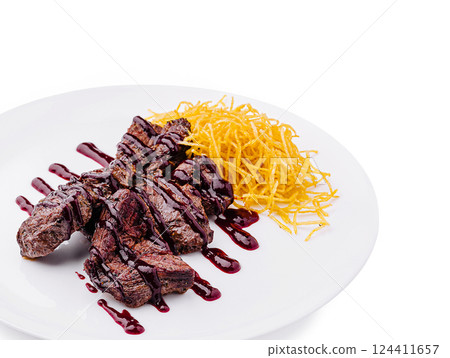 Steak with berry sauce and crispy golden garnish served on plate Steak with berry sauce and crispy golden garnish served on plate 124411657