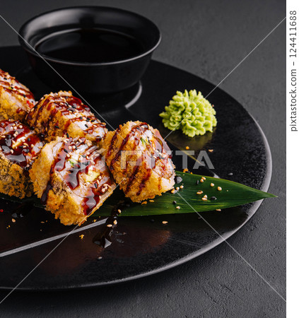 Exquisite sushi rolls on elegant dark plate Exquisite sushi rolls on elegant dark plate 124411688