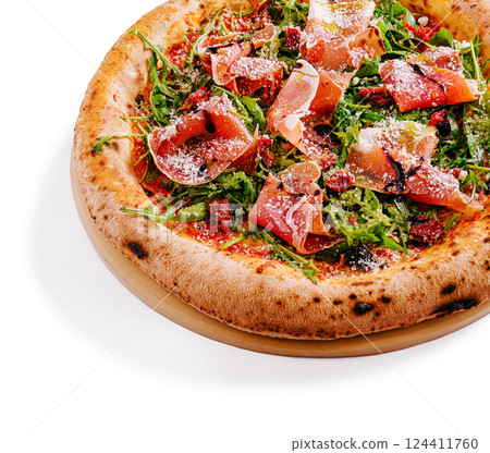 Delicious pizza topped with arugula and prosciutto on a wooden board Delicious pizza topped with arugula and prosciutto on a wooden board 124411760