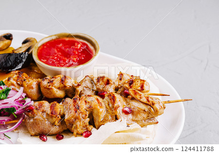 Grilled chicken skewers with vegetables and sauce Grilled chicken skewers with vegetables and sauce 124411788
