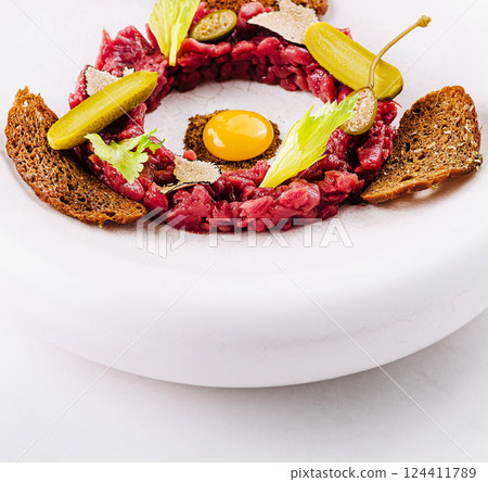 Deconstructed beef tartare with quail egg and rye bread 124411789