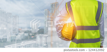 Civil engineer architect standing holding a safety helmet on construction and city background, Construction site plans to build high-rise buildings, Engineer building concept, Background of copy space 124412092