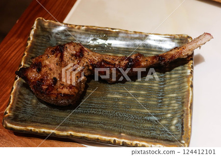 close up of grilled lamb meat mutton drumstick rack on a green plate with copy space close up of grilled lamb meat mutton drumstick rack on a green plate with copy space 124412101