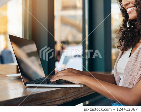 Hands of a woman operating a laptop in a cafe 124412367