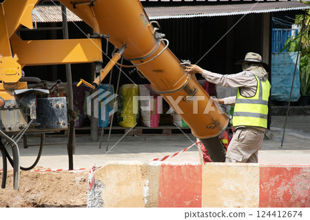 Engineers are overseeing the pouring of concrete. Engineers are overseeing the pouring of concrete. 124412674
