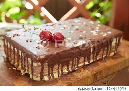 Delicious chocolate cake decorated with cherries. Delicious chocolate cake decorated with cherries. 124413054