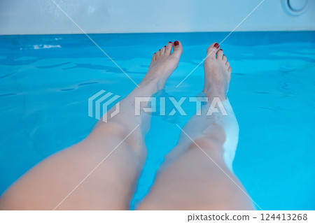 Women's feet in a saltwater pool. Water spa treatments in the sanatorium. Women's feet in a saltwater pool. Water spa treatments in the sanatorium. 124413268