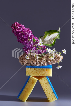 Creative composition of sponges, wood and flowers. Advertisement idea. Copy space 124413288