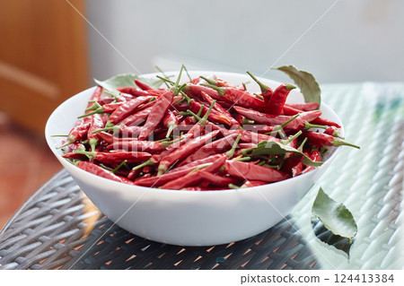 Pickled red hot peppers in a ceramic dish. 124413384